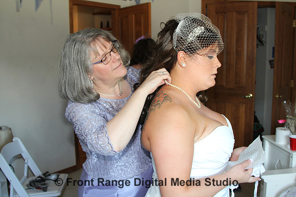 Mom adjusting the bride's necklace.
